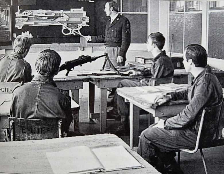 Leslokalen met militaire leerlingen en instructiemodel mitrailleur MAG