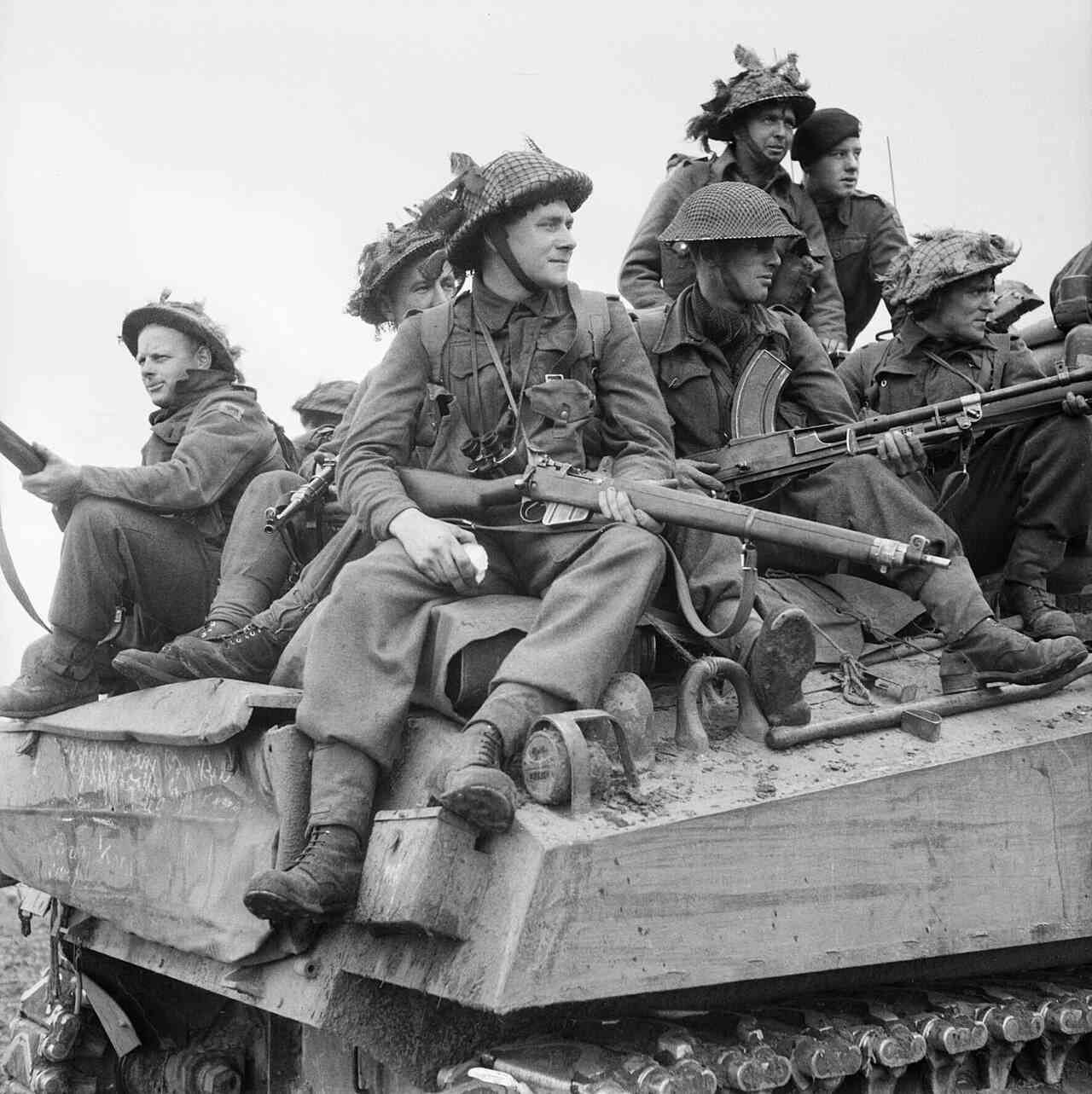 Britse infanteristen acjter op Sherman tank