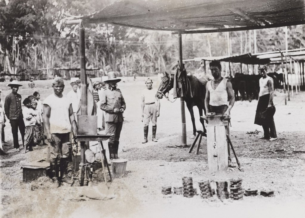 Hoefsmid vab het knil aan het werk in zijn smidse in Indiƫ in 1925