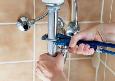 plumber fixing a water pipe in a bathroom plumber fixing a water pipe in a bathroom