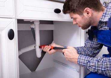 plumber repairing the sink plumbing in a residential property plumber repairing the sink plumbing in a residential property