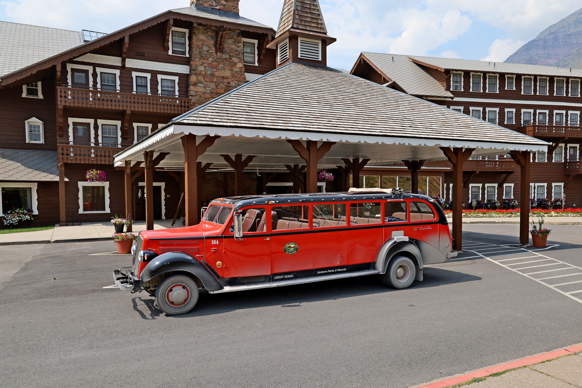 Many Glacier Hotel, met een toerbus die door Glacier National Park rijdt