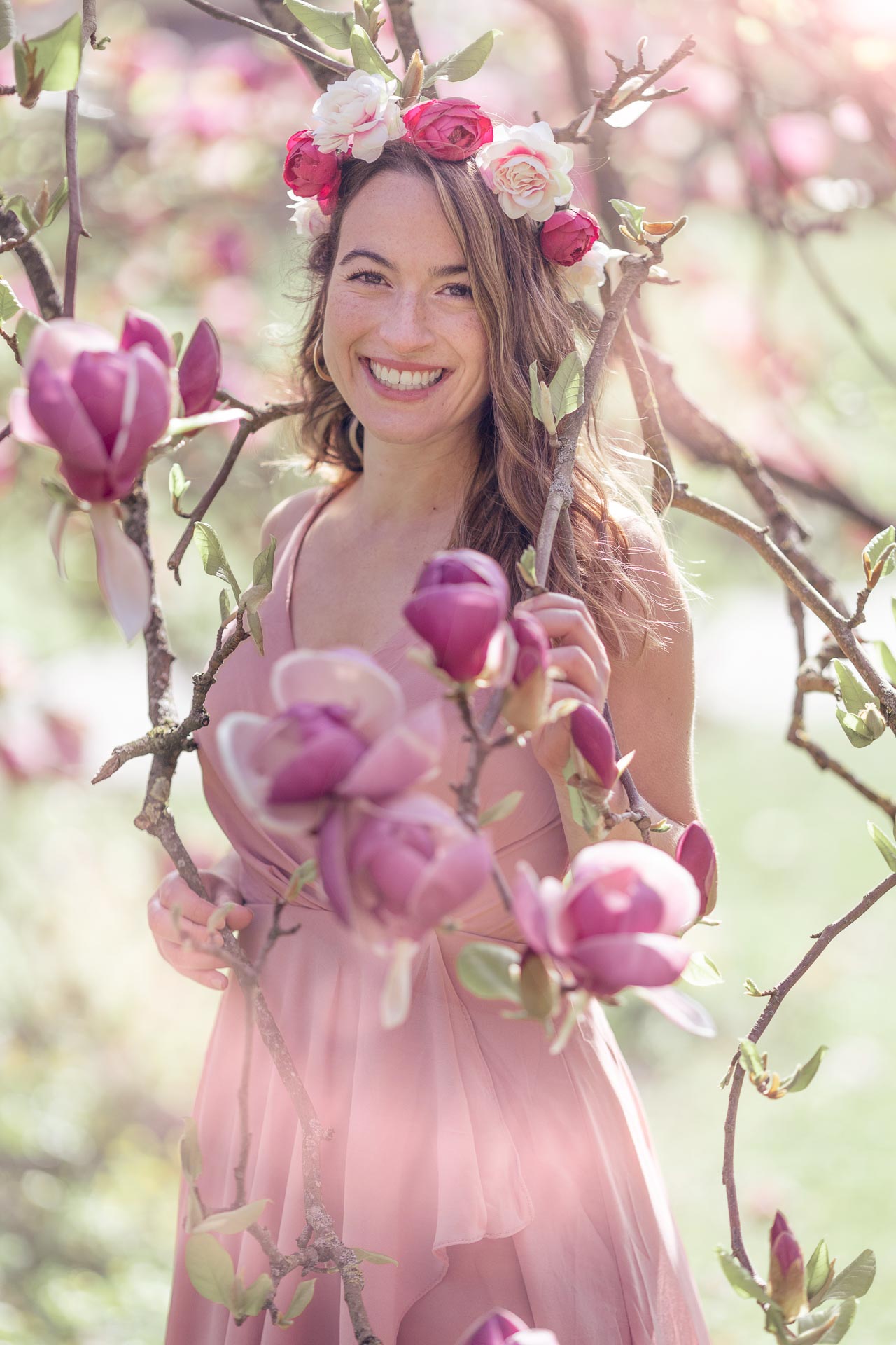 jeune femme souriante dans un magnolia en fleur