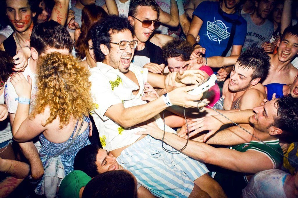 Públic eufòric al voltant d'un artista amb una Game Boy