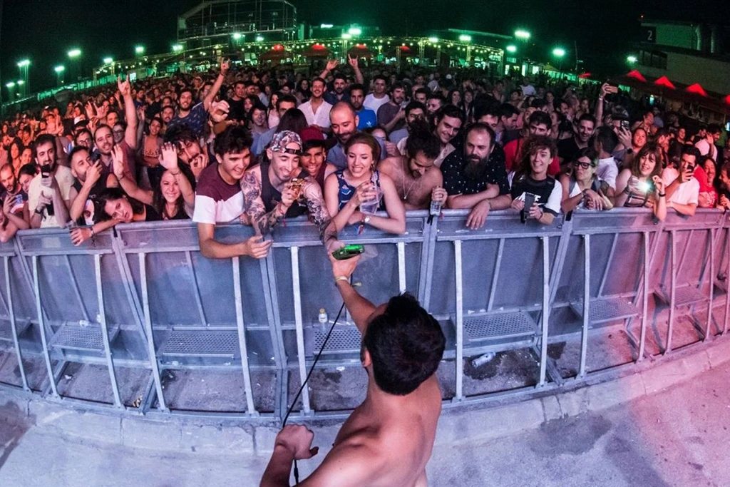 Públic en un festival amb l'artista aixecant una Game Boy