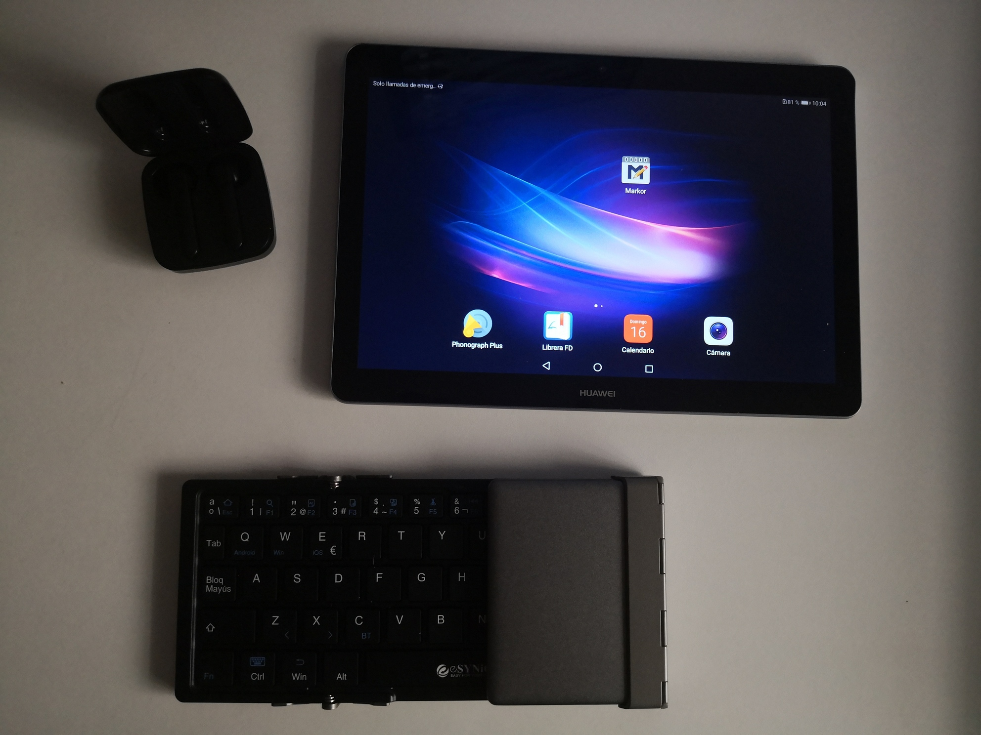Tablet con lo mínimo instalado, unos auriculares bluetooth y un teclado plegable bluetooth