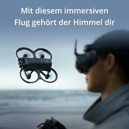Person steuert Drohne mit VR-Headset am Strand.