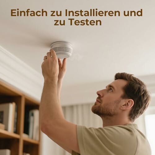 Mann installiert Rauchmelder an der Decke.